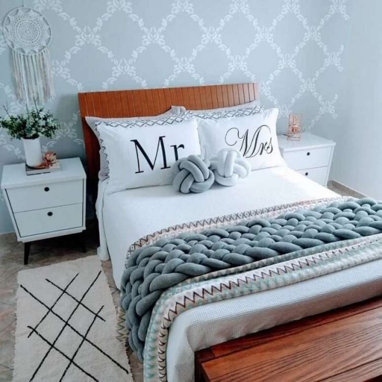 54. Quarto de casal rom&acirc;ntico com papel de parede delicado e mesa de cabeceira retr&ocirc; branca. Fonte: Renides Eller