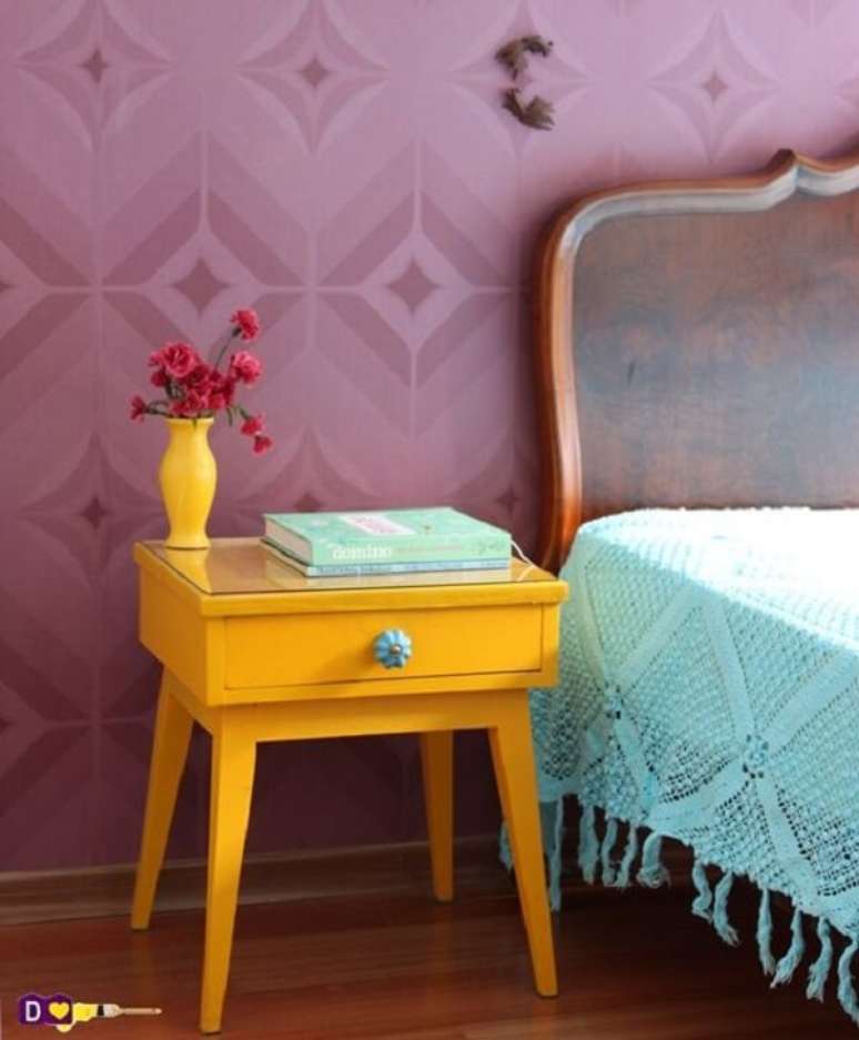 50. Quarto colorido com mesa de cabeceira retrô amarela, papel de parede roxo e colcha azul. Fonte: Pinterest