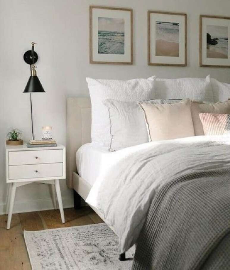 33. Mesa de cabeceira retrô branca decora o quarto de casal com arandela preta moderna. Foto: Isabella Simth