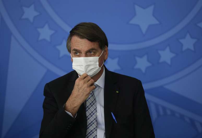 Presidente da República, Jair Bolsonaro (sem partido), usa uma máscara de proteção facial contra a covid-19 durante cerimônia para sancionar projetos de lei que ampliam a capacidade de aquisição de vacinas pelo governo federal
