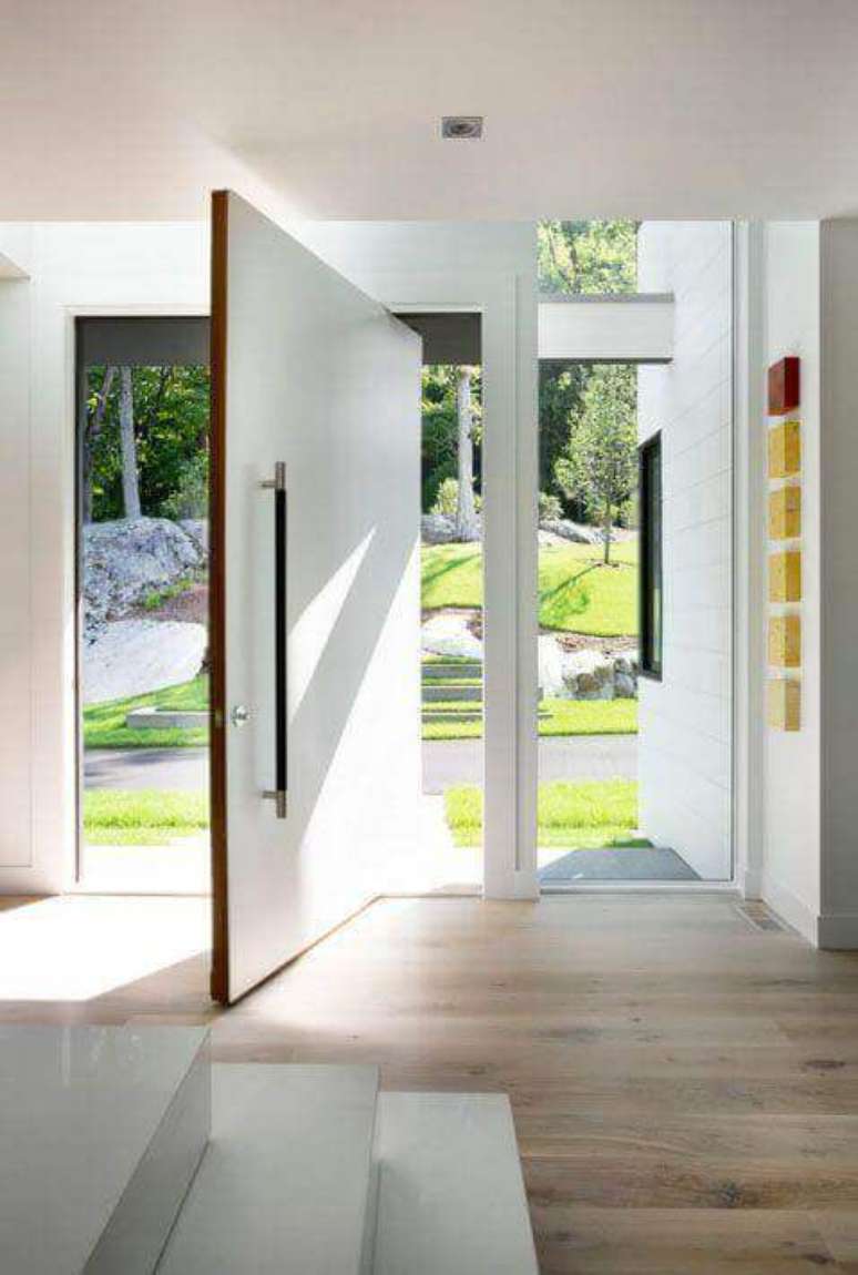 7. A porta pivotante branca é perfeita para decorar a entrada de casa – Foto LDA Arquitecture e Interiors