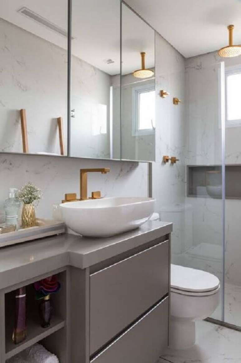 40. Espelheira grande para banheiro cinza moderno decorado com detalhes em dourado – Foto Jeito de Casa