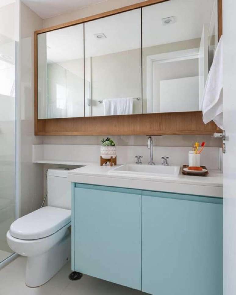 20. Decoração com gabinete azul pastel e espelheira para banheiro de madeira – Foto Jeito de Casa