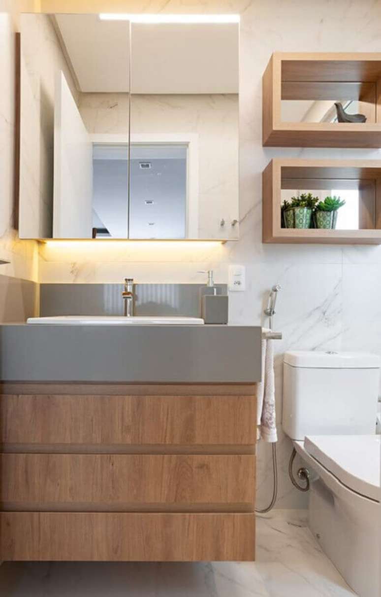 54. Espelheira para banheiro simples decorado com gabinete e nichos de madeira – Foto Jeito de Casa