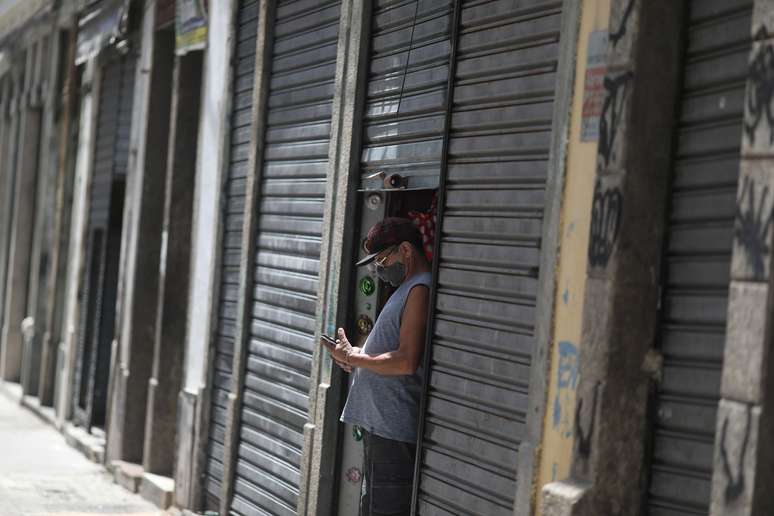 Homem olha o celular ao lado de lojas fechadas no Rio de Janeiro
04/03/2021 REUTERS/Pilar Olivares