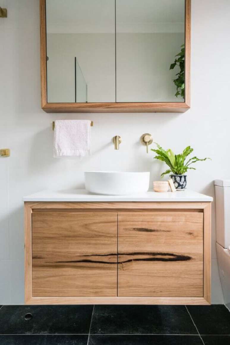 22. Decoração com gabinete de madeira e espelheira para banheiro simples – Foto Just in Place