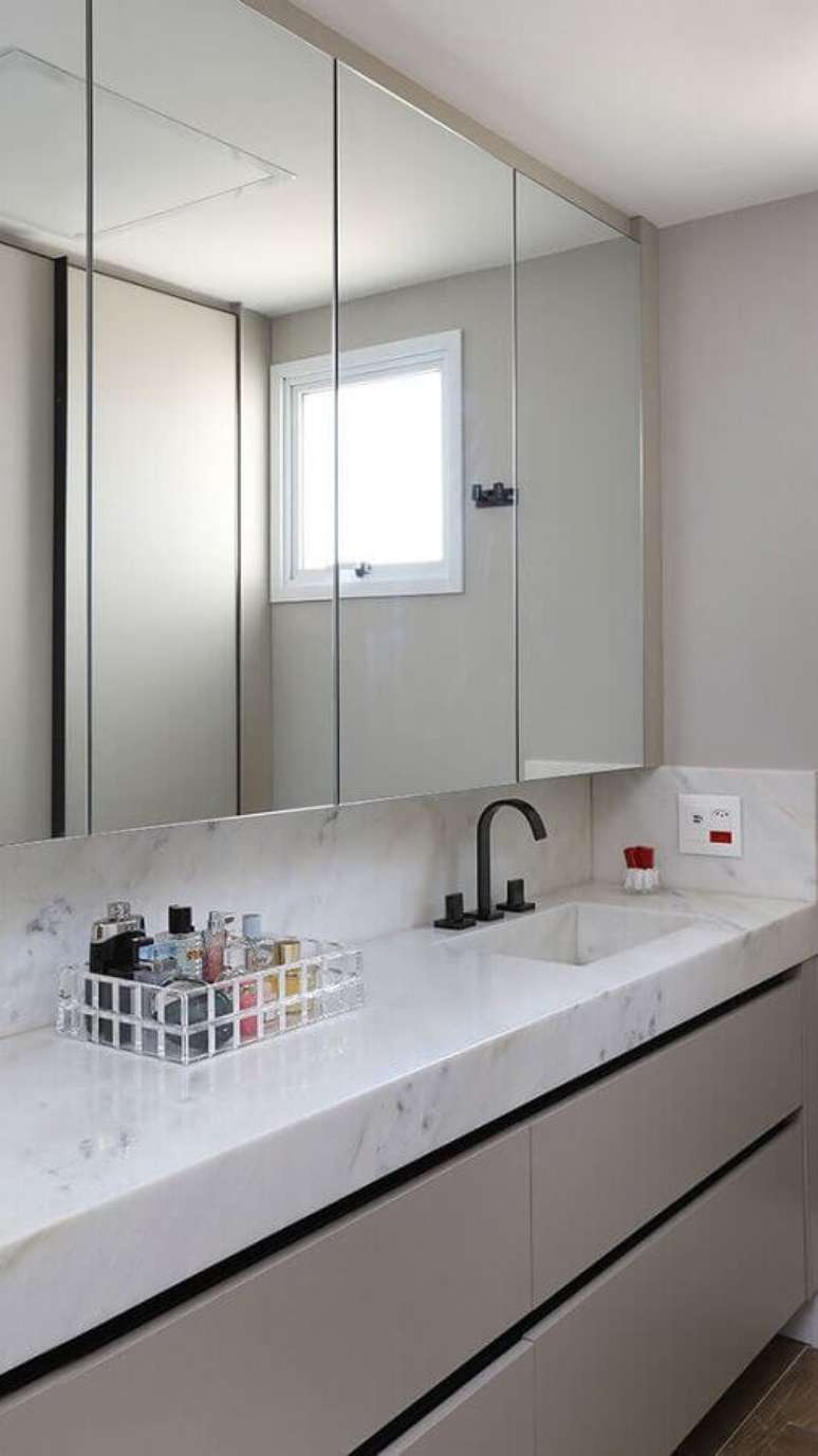 35. Decoração sofisticada com bancada de mármore e espelheira grande para banheiro – Foto Revista Habitare