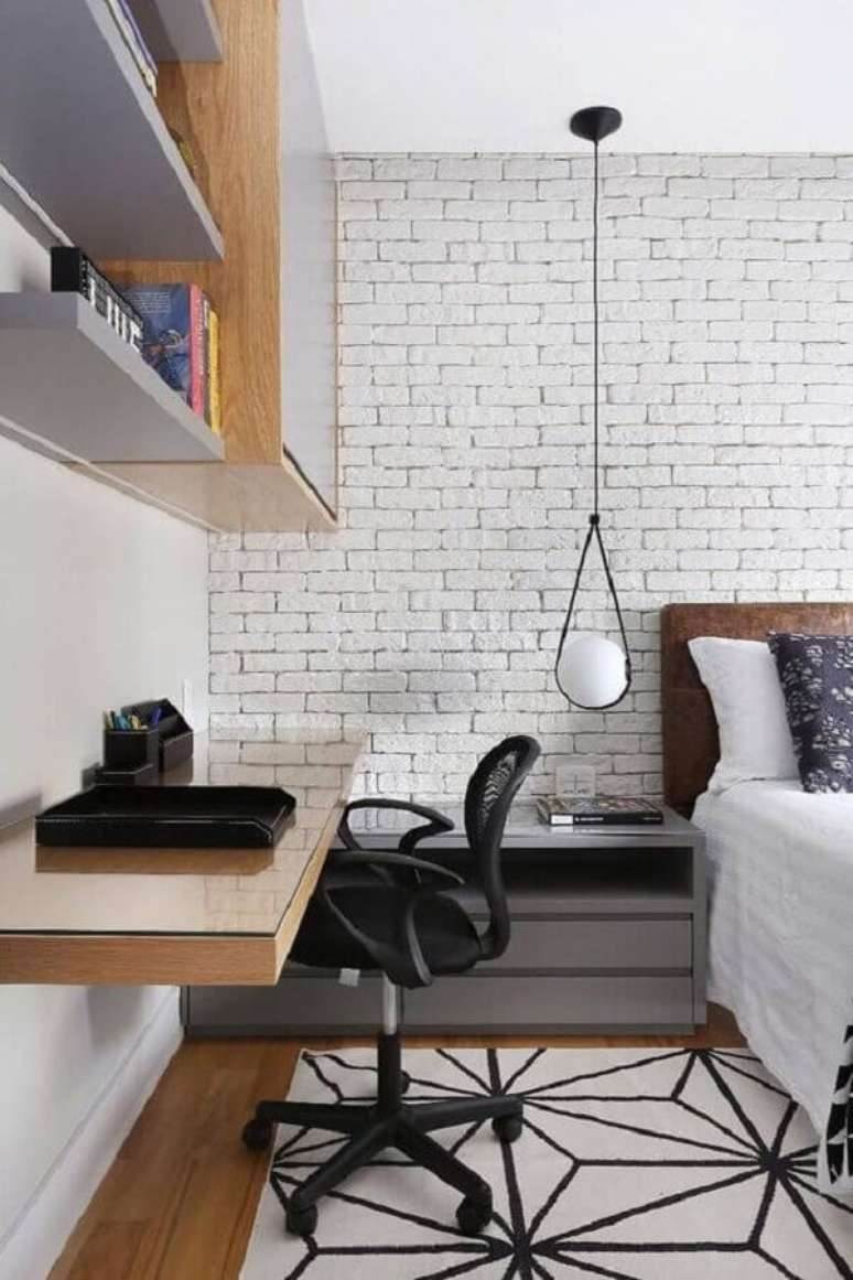 1. Bancada suspensa para home office no quarto moderno decorado com parede tijolinho branco. Foto: Zuleide Borges