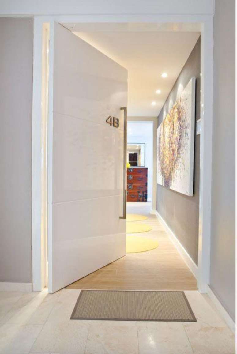 21. Porta pivotante branca e grande para entrada de apartamento moderno – Foto AD&E