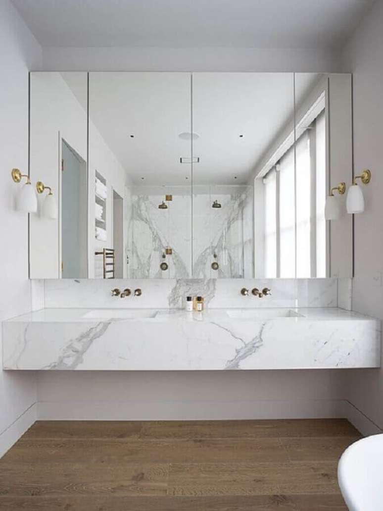14. Bancada de mármore para banheiro branco decorado com arandela de parede – Foto Arkpad