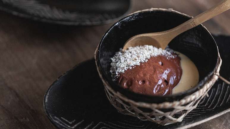 Doce criado por Bel Coelho com espuma morna de chocolate 70, cacau, creme de cumaru, doce de bacuri e farofa de castanha do Pará