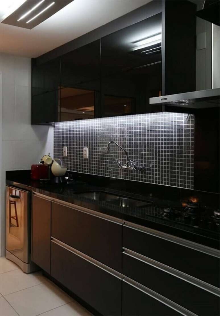 47. A luz de LED embutida no armário aéreo realça a presença da pastilha preta na cozinha. Fonte: Pinterest
