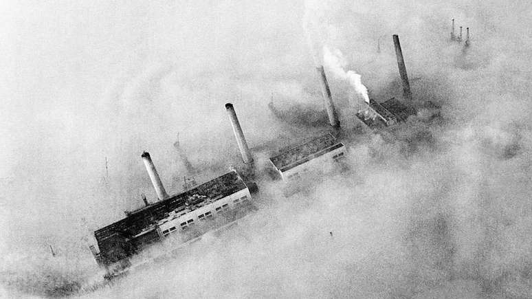 Pode parecer um transatlântico afundando no mar, mas são chaminés de fábricas que surgem em meio à poluição no East End de Londres em 1952