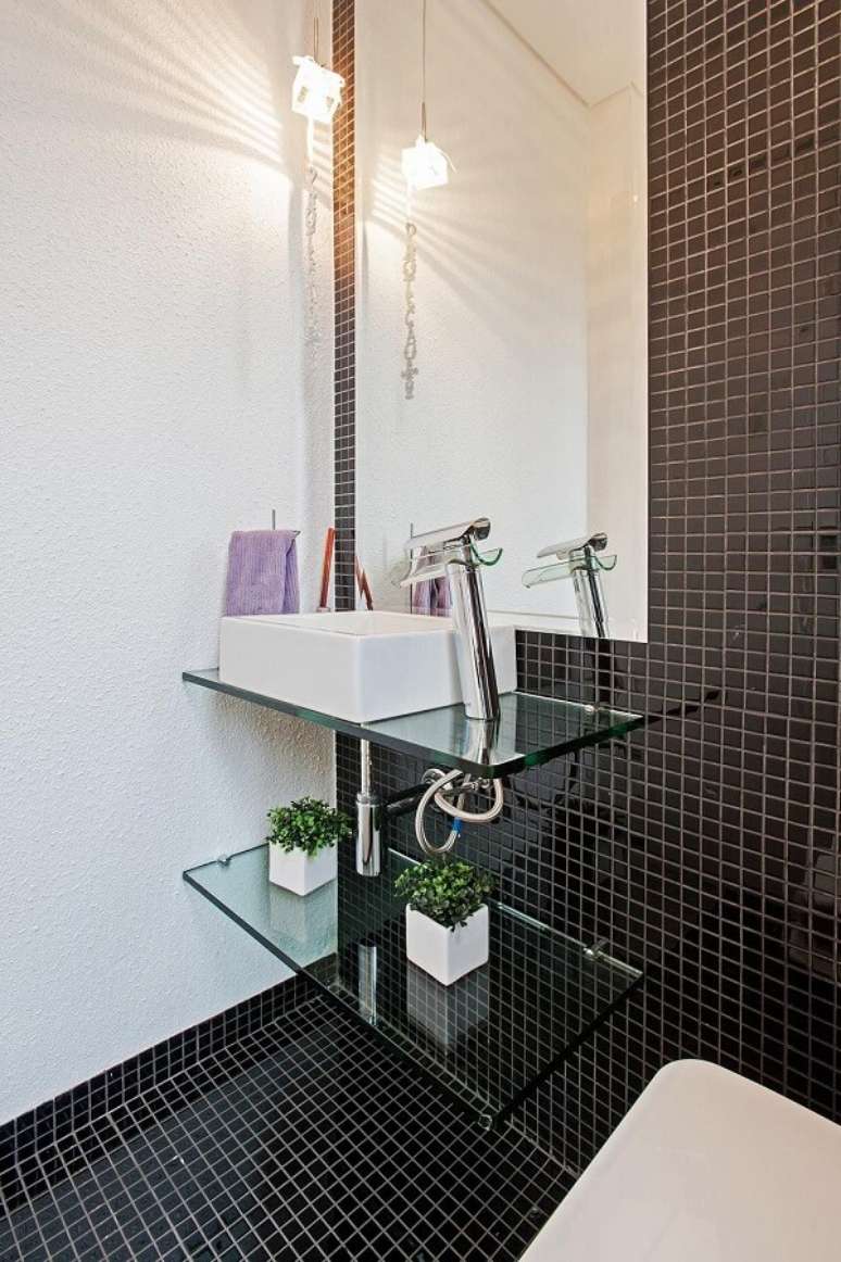 14. Na decoração desse lavabo piso e parede recebem acabamento em pastilha preta. Projeto por Patrícia Azoni