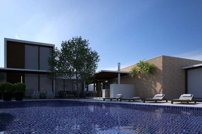 13. Espregui&ccedil;adeiras de madeira e azulejo azul para piscina decoram a &aacute;rea de lazer do terreno. Projeto por Oleg&aacute;rio de S&aacute; & Gilberto Cioni