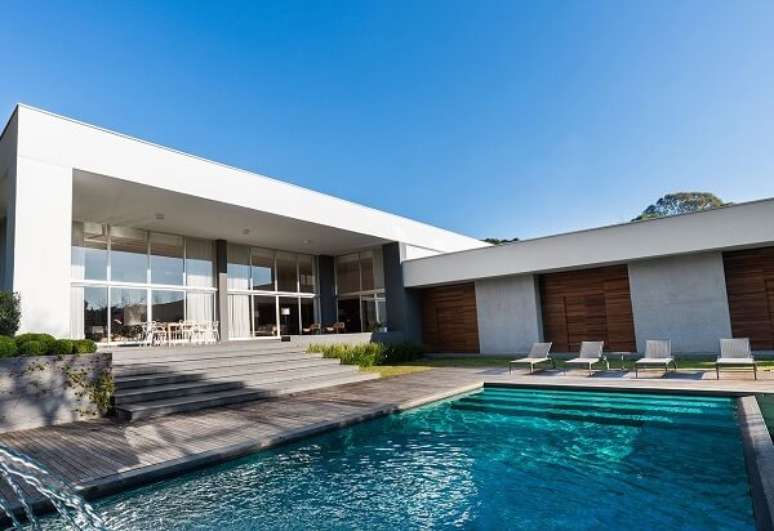 32. O deck de madeira e o azulejo azul para piscina formam uma linda composi&ccedil;&atilde;o na &aacute;rea externa. Projeto por Leonardo Muller