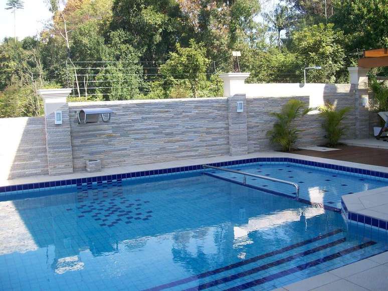26. O azulejo para piscina em tons de azul foi usado em conjunto com o azulejo branco. Projeto por Alessanara Maioli