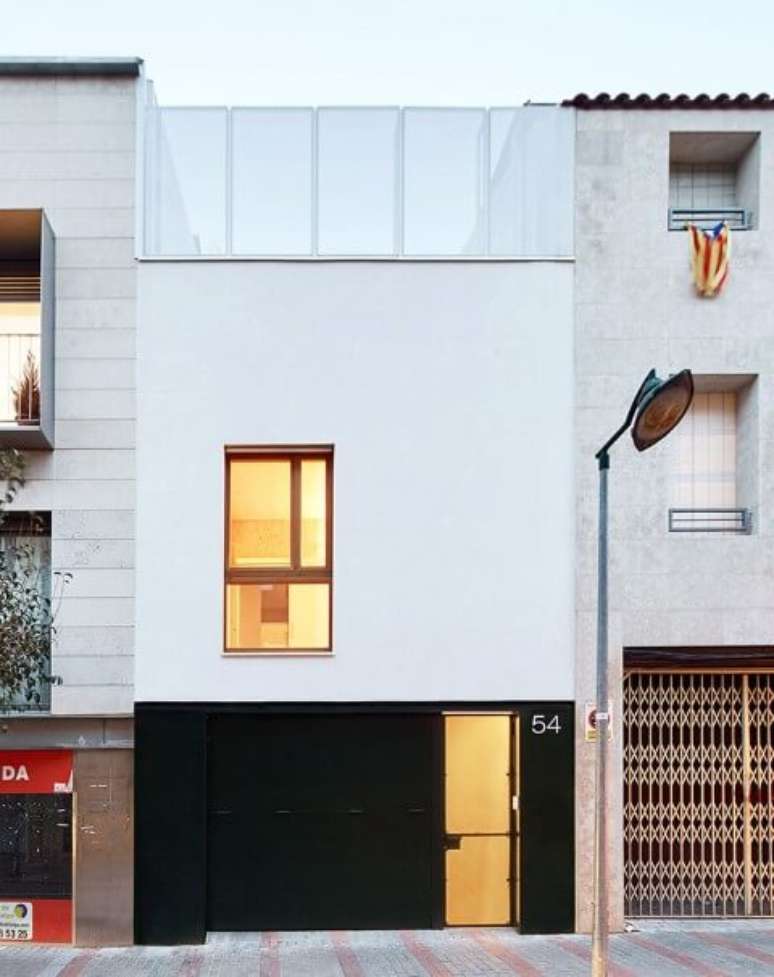 14. Portão de ferro preto em casa com fachada branca minimalista. Foto de Jose Hevia