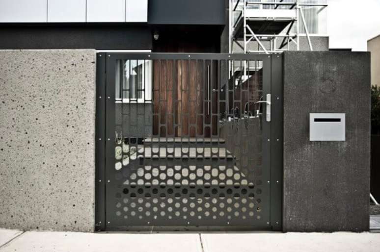 40. Portão de ferro cinza vazado combinando com projeto de casa moderna com muro preto. Foto de Pierre Le Roux Design
