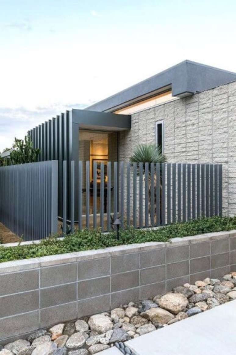 16. Portão de ferro cinza em fachada de casa moderna. Foto de News Ease