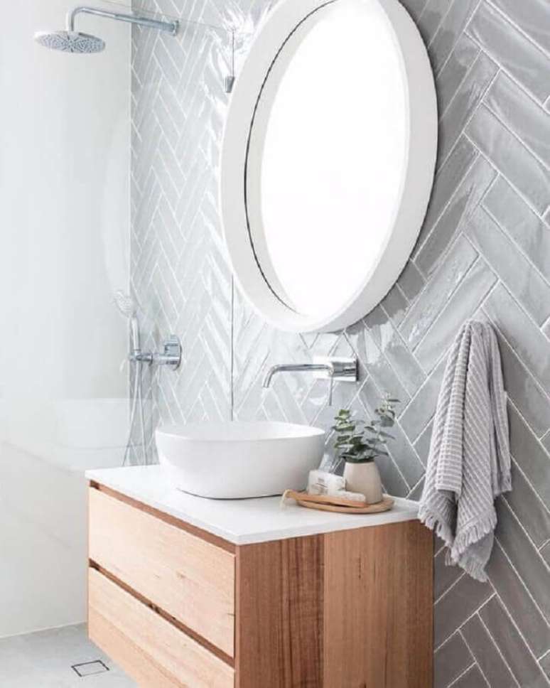 41. Decoração com espelho redondo e azulejo de banheiro cinza claro. Foto: Pinterest