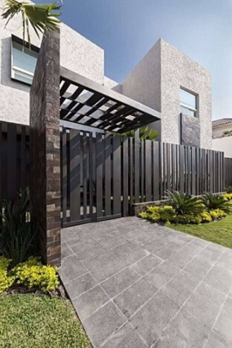 42. Fachada com port&atilde;o de ferro preto e parte do muro de pedras. Foto de Pinterest