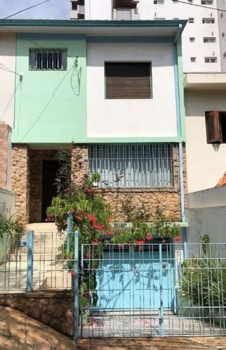 41. Port&atilde;o de ferro azul vazado em casa grande e colorida. Foto de Pinosy