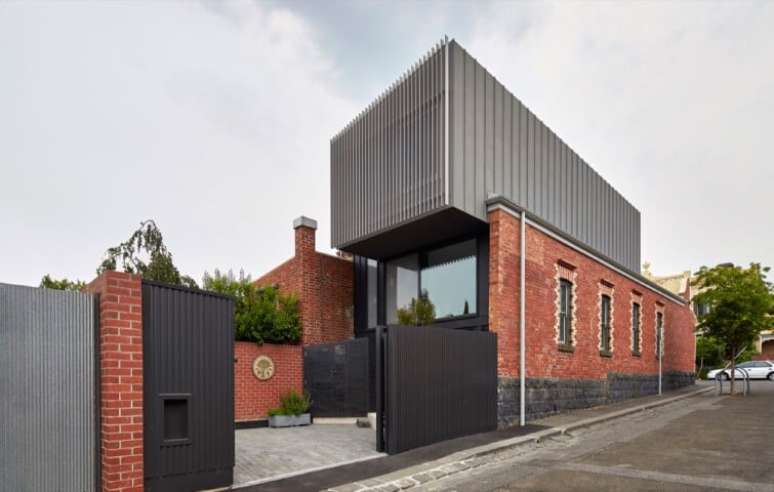 32. Portão de ferro preto em casa grande com muro de tijolinhos. Foto de Home DSGN