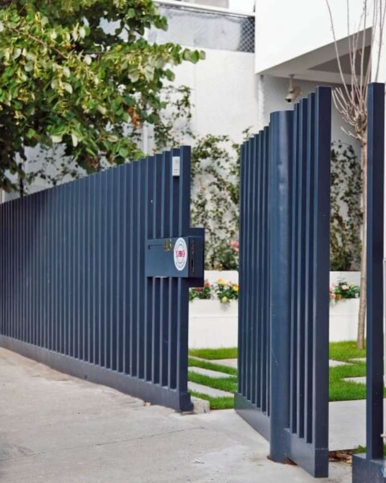 7. Portão de ferro azul com porta pivotante embutida. Foto de Home DSGN
