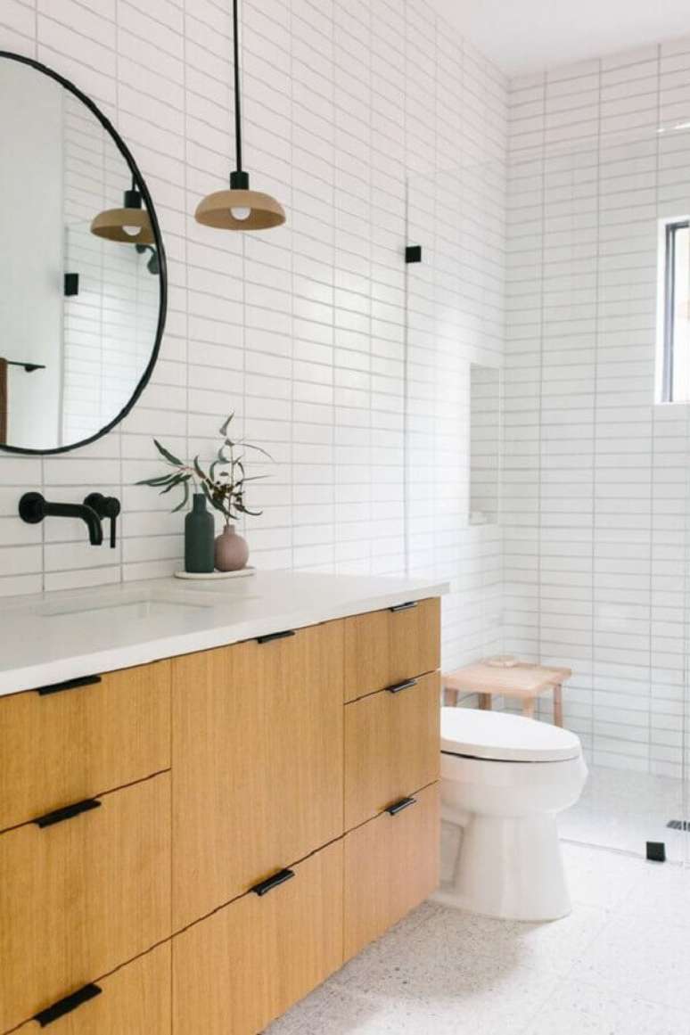 2. Azulejo para parede de banheiro branco decorado com gabinete de madeira. Foto: Homedit