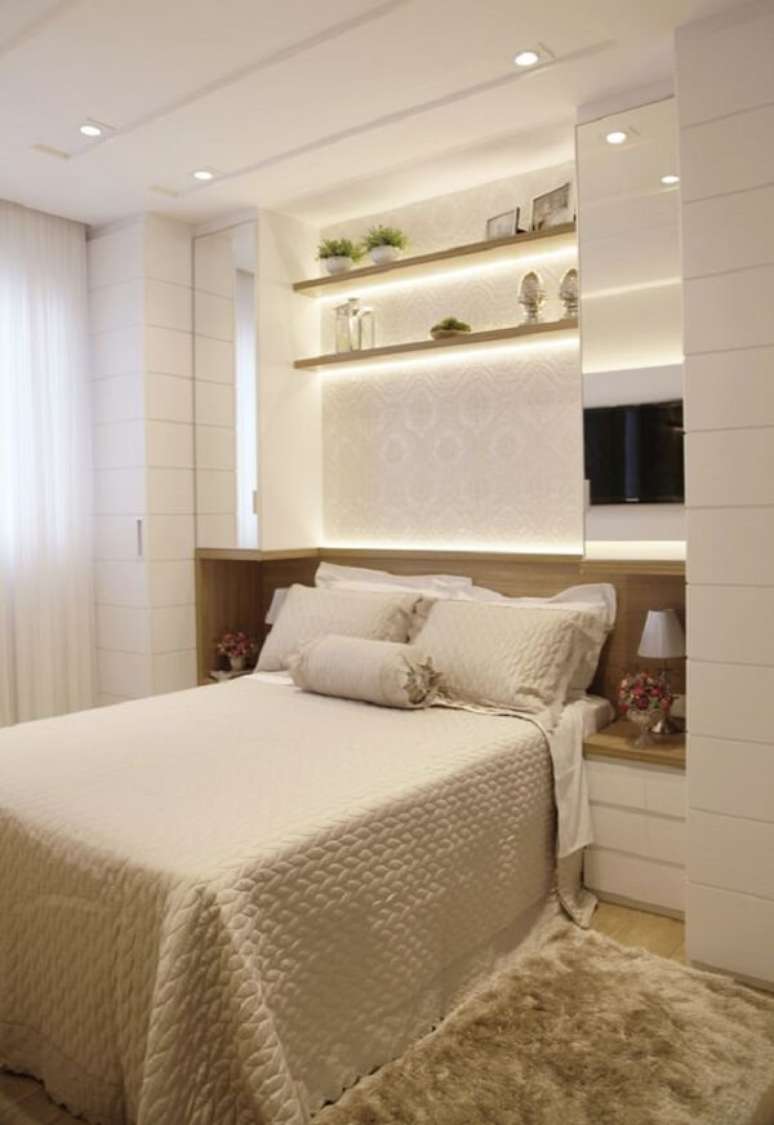 9. A iluminação traz um toque especial para essa cama com guarda-roupa embutido. Fonte: Suelen Kuss Arquitetura