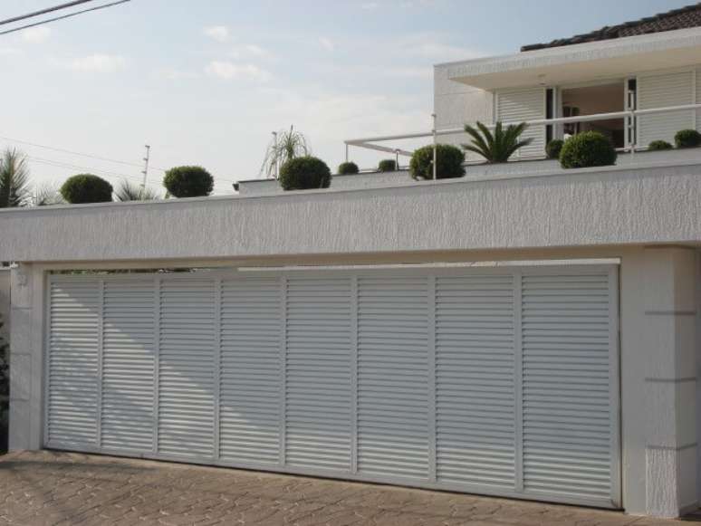 57. Port&atilde;o de ferro amplo combinando com a fachada clara da casa. Foto de Tampa Roofer