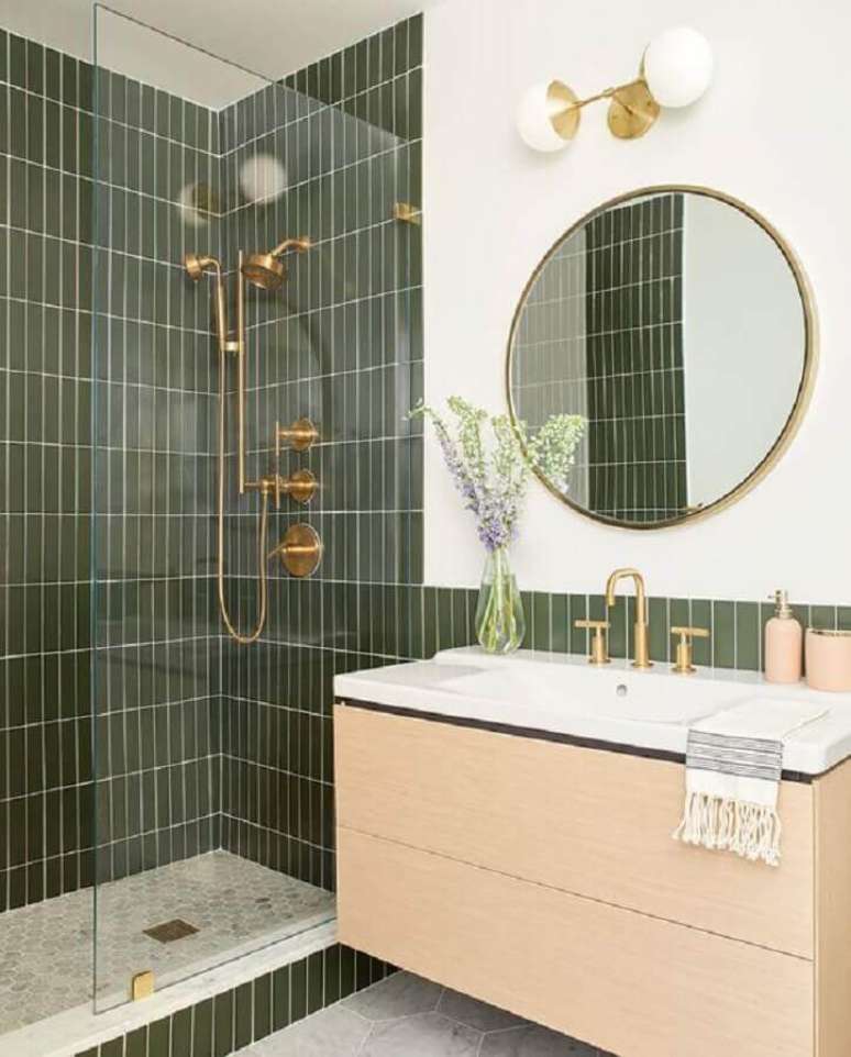 8. Azulejo para parede de banheiro verde decorado com gabinete suspenso de madeira clara. Foto: Casa de Valentina