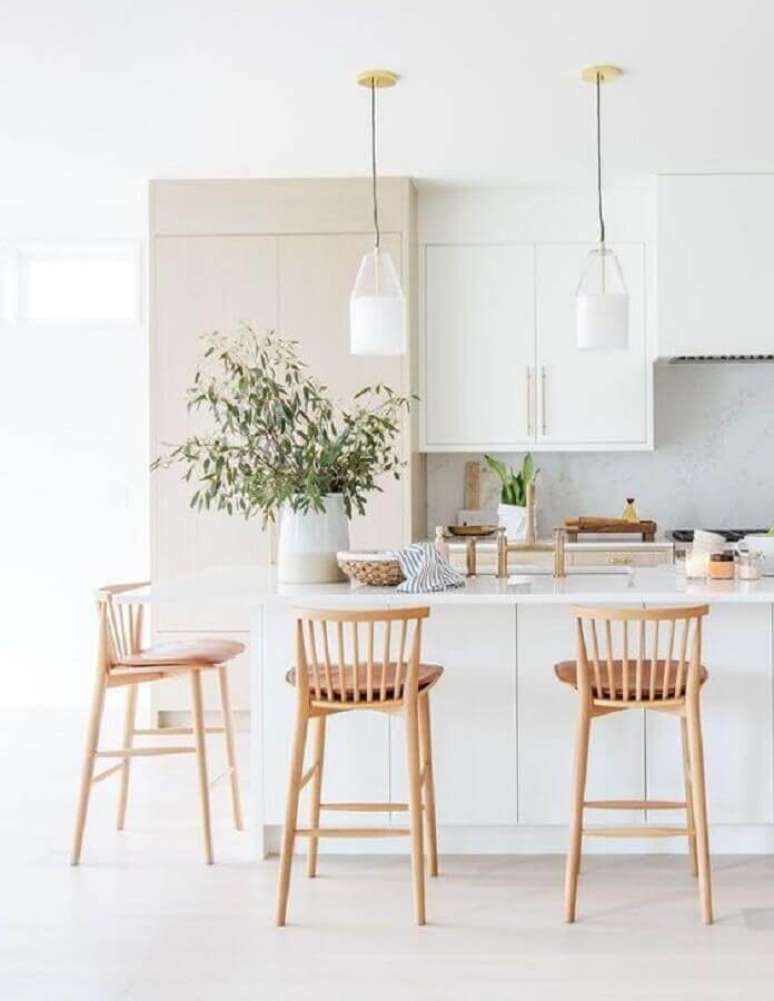 51. Cozinha branca clean decorada com banquetas para bancada de madeira. Foto: Apartment Therapy