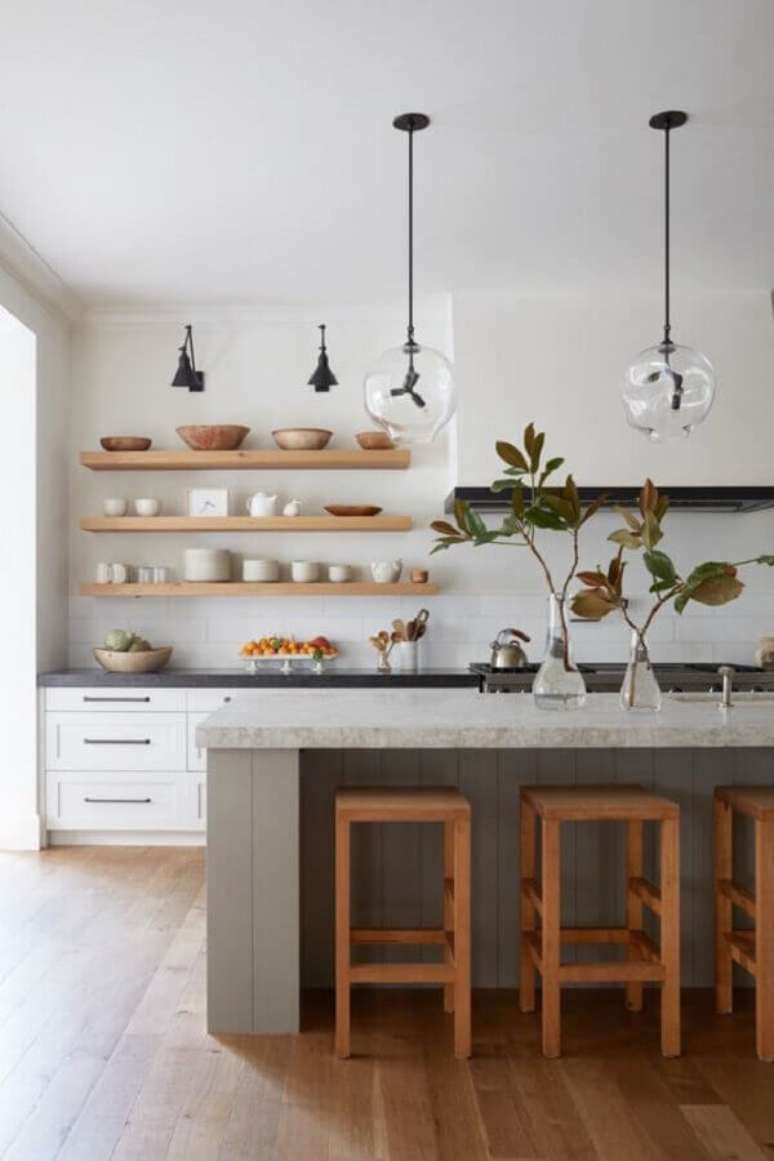 44. Cozinha com ilha decorada com banquetas de madeira para bancada. Foto: McGee & Co.