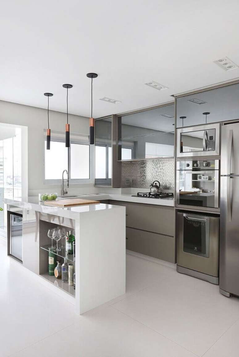 54. Decoração de cozinha planejada com armários espelhados e luminária pendente moderna para bancada – Foto Pinterest