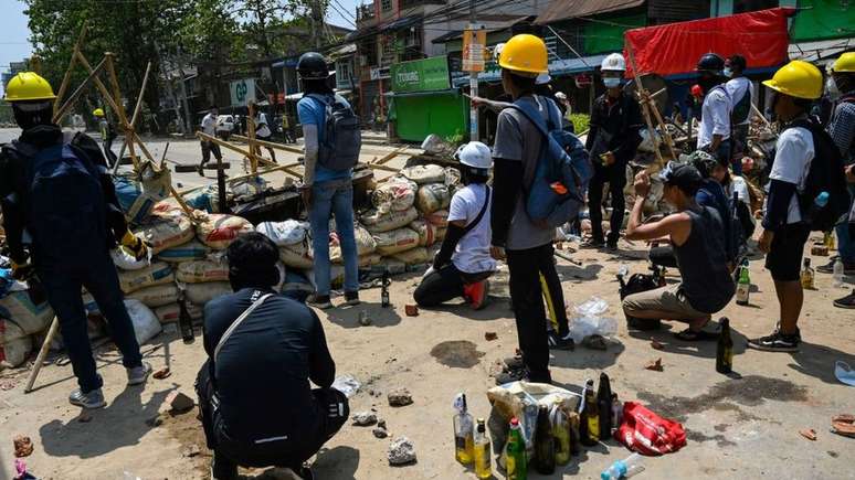 Manifestantes atrás de barricadas no município de Thaketa, em Yangon, na sexta-feira