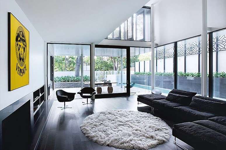 23. Piso vinilico preto para decoração de sala ampla com tapete redondo felpudo – Foto Futurist Architecture