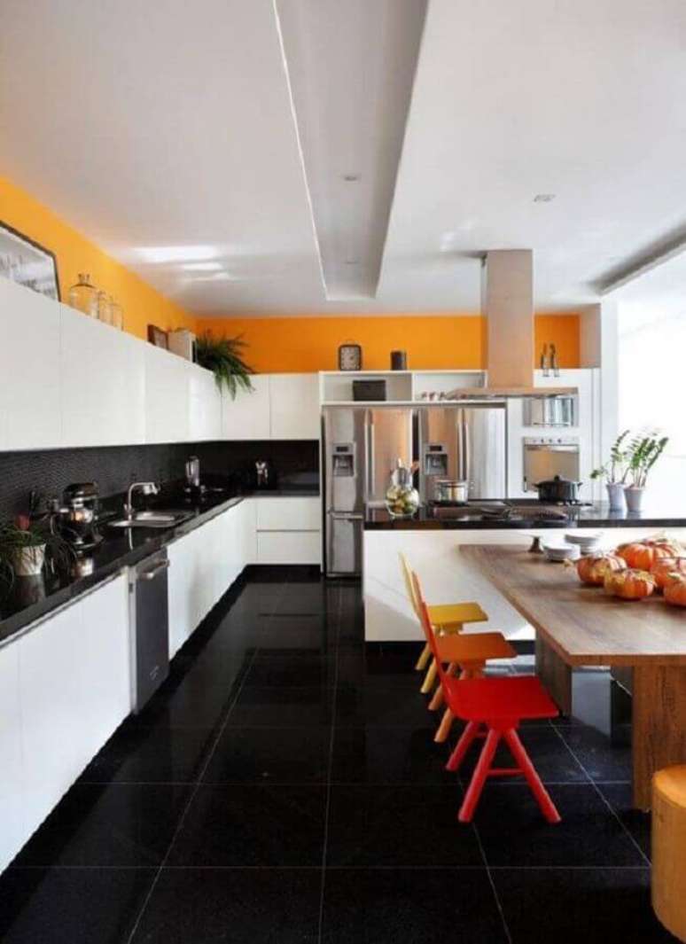 15. Piso preto para cozinha ampla decorada com cadeiras coloridas para ilha – Foto Houzz
