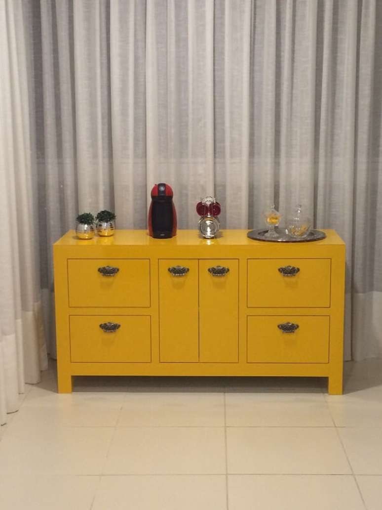 36. O aparador amarelo para sala serve de apoio para cafeteira. Fonte: Giselle Jaeger Silva de Moraes