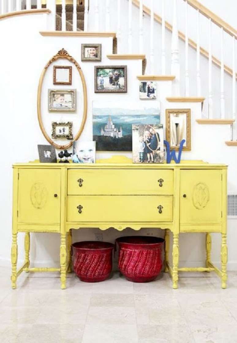11. Acomode v&aacute;rios porta retratos sobre o aparador amarelo. Fonte: Pinterest