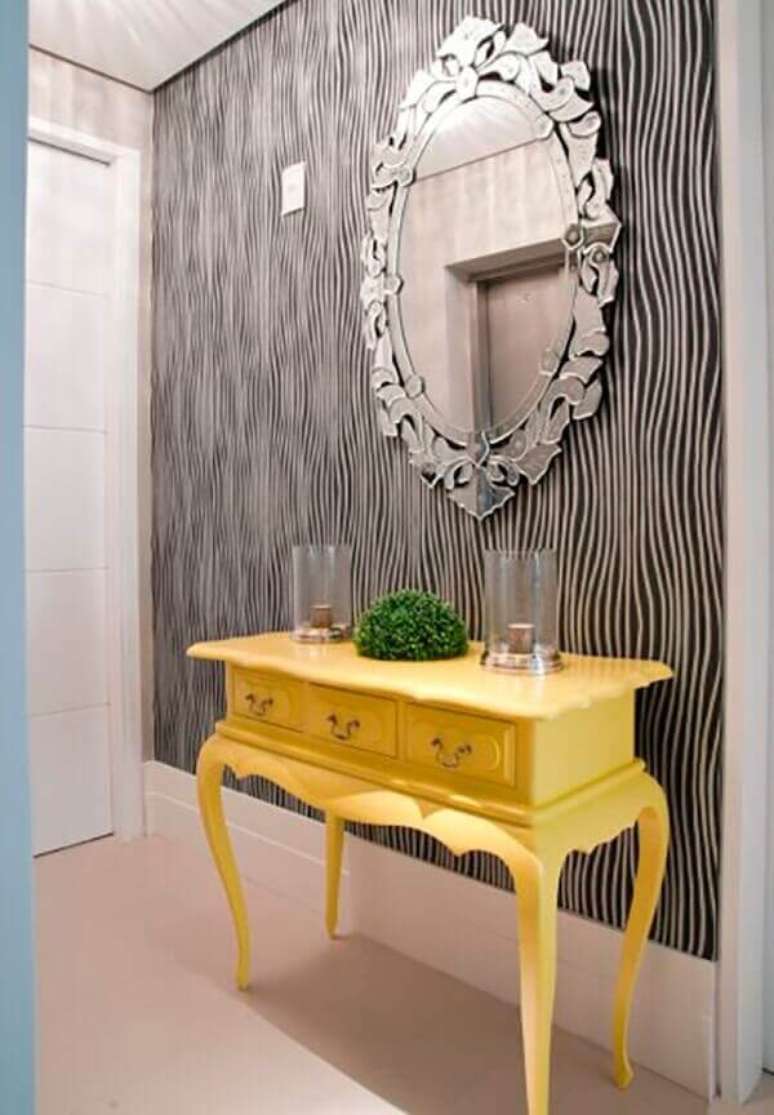 30. O aparador amarelo com espelho fixado na parede decora a entrada da casa. Fonte: Pinterest
