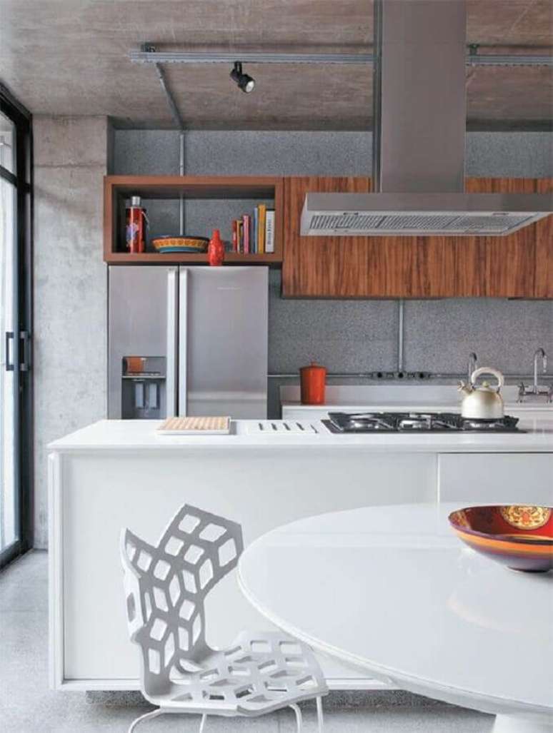 58. Ilha gourmet para cozinha moderna planejada com armários de madeira e cimento queimado – Foto: Planete Deco