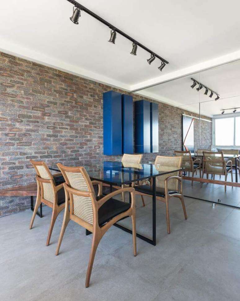 67. Decora&ccedil;&atilde;o de sala com parede tijolinho e cadeiras de madeira para mesa de jantar de vidro &ndash; Foto: Casa de Valentina