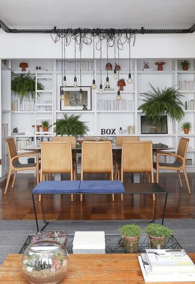 33. Sala de jantar decorada com estante branca e cadeiras de madeira para mesa de jantar – Foto: Pinterest