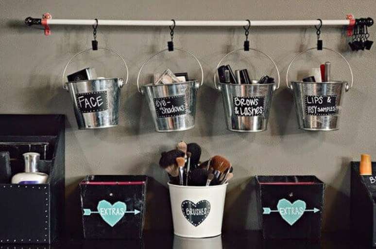 47. Pequenos baldinhos pendurados s&atilde;o charmosos organizadores de cosm&eacute;ticos e podem ficar fixados sobre a penteadeira preta. Fonte: Dicas de Mulher