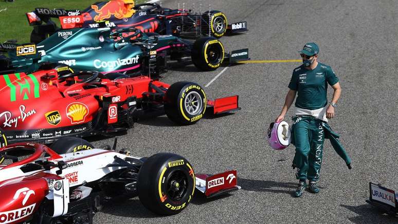 Sebastian Vettel, agora com o macacão verde da Aston Martin, observa os novos carros da Fórmula 1.