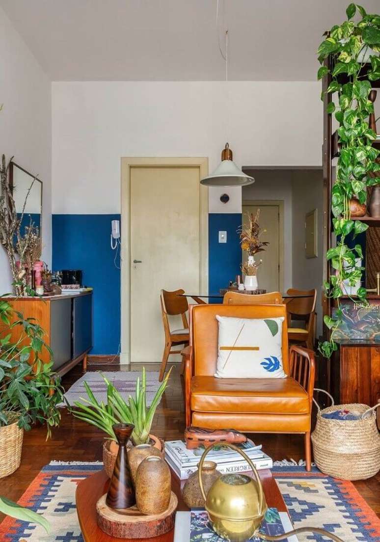 54. Sala simples decorada com vasos de plantas e poltrona marrom de couro – Foto: Histórias de Casa