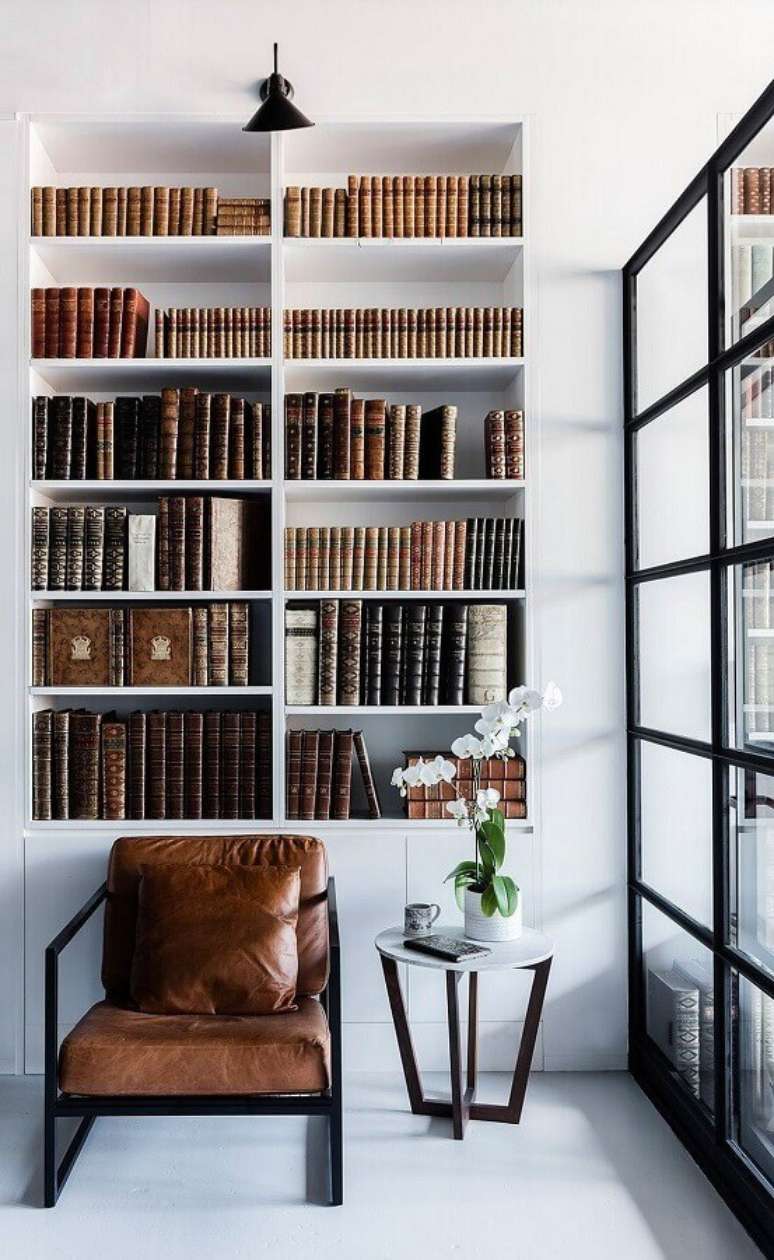 41. Poltrona marrom escuro moderna para decoração de cantinho de leitura com estante planejada para livros – Foto: Futurist Architecture