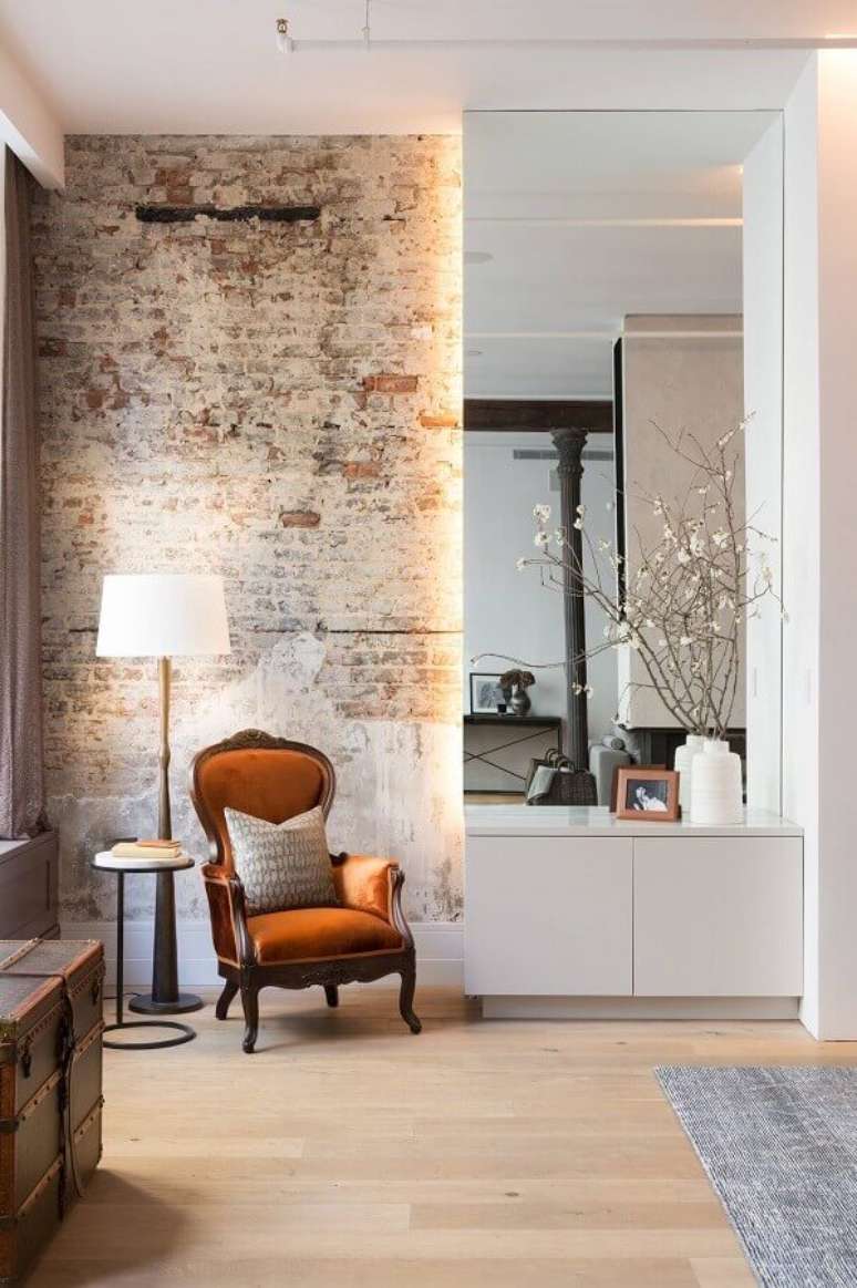 17. Ambiente decorado com parede de tijolinho rústica e poltrona marrom antiga – Foto: HomeAdore